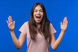 Big large concept. Teen girl showing invisible abstract subject or object sizes. Size matters. Blue studio background