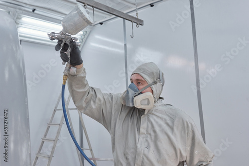 Horizontal medium side view shot of car painter working in auto service centre photo