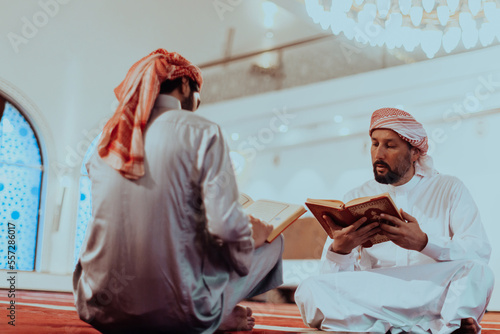 A group of Muslims reading the holy book of the Quran in a modern mosque during the Muslim holiday of Ramadan
