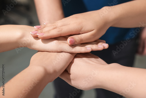 Group of people holding hands together indoors  closeup. Unity concept
