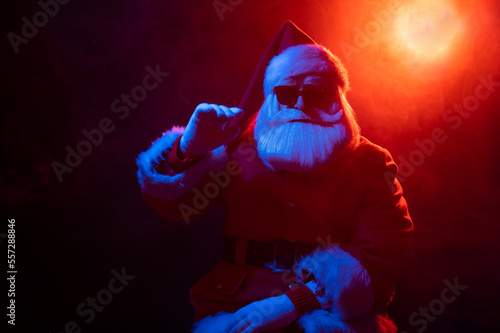 Portrait of Santa Claus in sunglasses in neon light.