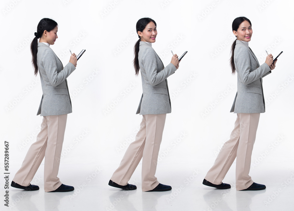 Full Length 20s Asian Woman wear formal business blazer suit dress pant shoes. Black long straight hair female hold tablet work confident, walking forward turn left right, white background isolated Full Length 20s Asian Woman wear formal business blazer suit dress pant shoes. Black long straight hair female hold tablet work confident, walking forward turn left right, white background isolated