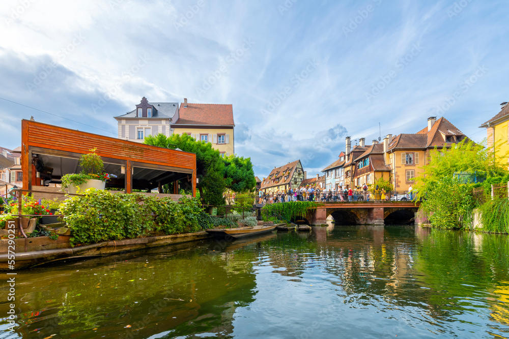 View of the Rue Turenne bridge and half timber buildings from a boat on the Lauch canal in the historic medieval Petite Venice district of Colmar, France, in the Alsace region.	