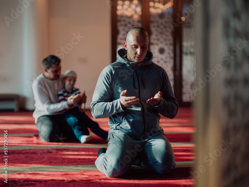 A group of Muslims in a modern mosque praying the Muslim prayer namaz, during the holy month of Ramadan