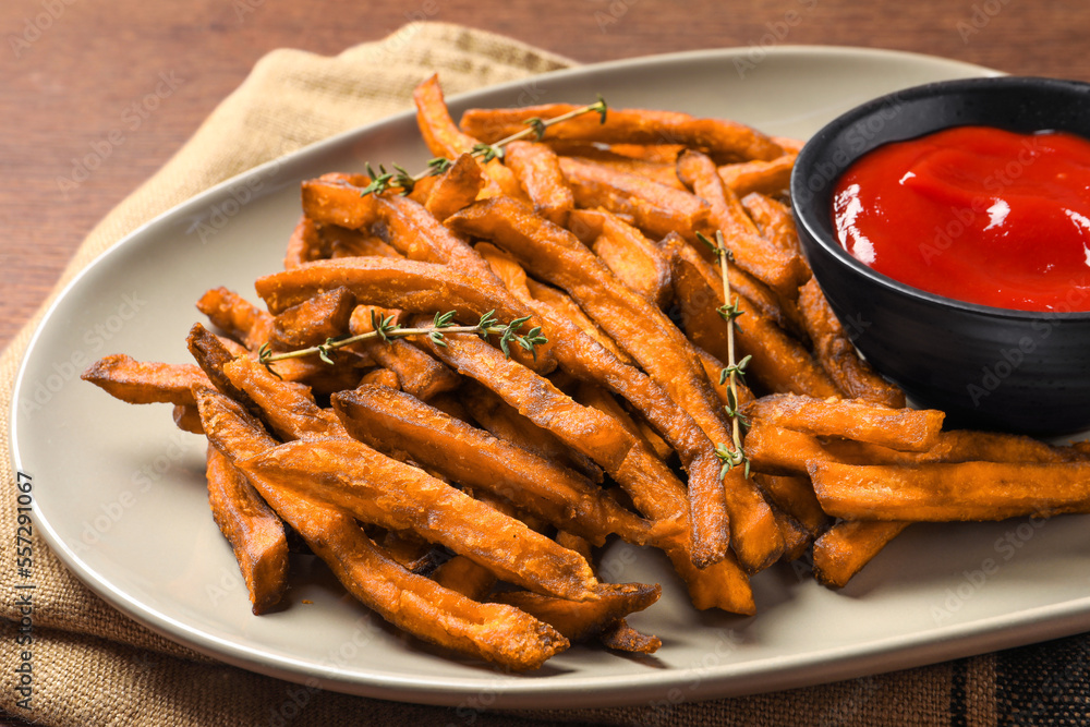 Sweet tasty potato fries and ketchup on table, closeup Sweet tasty potato fries and ketchup on table, closeup