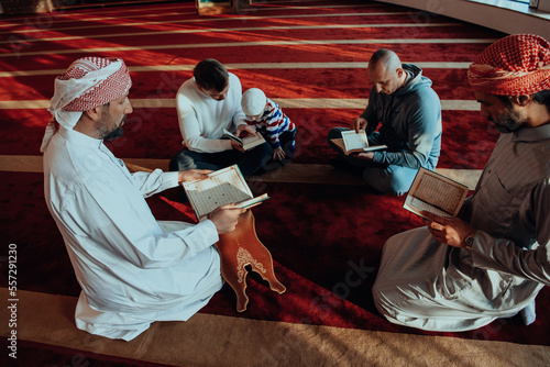 A group of Muslims reading the holy book of the Quran in a modern mosque during the Muslim holiday of Ramadan