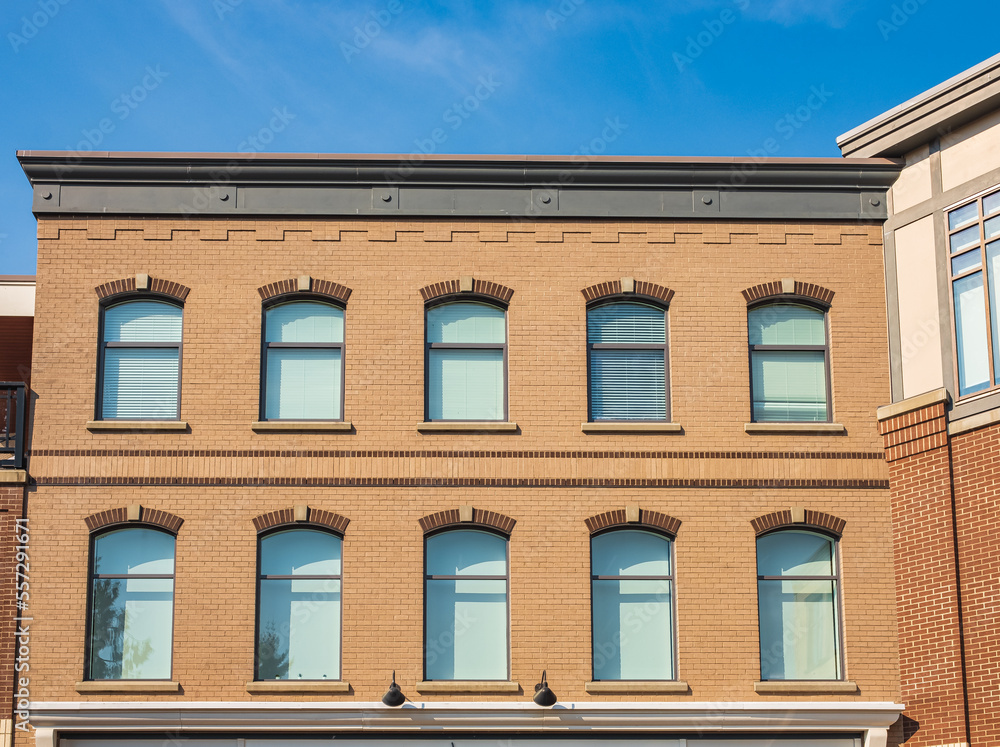 Fototapeta premium Beautiful view of building with arched windows. Windows with shutters on a vitage residential building facade