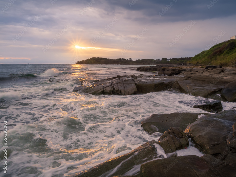 Coastal Sunrise with Waves Crashing on Rocks