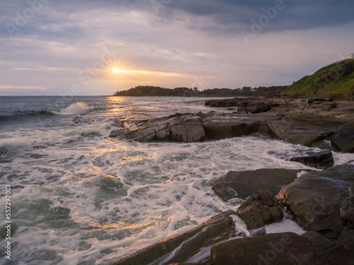 Coastal Sunrise with Waves Crashing on Rocks