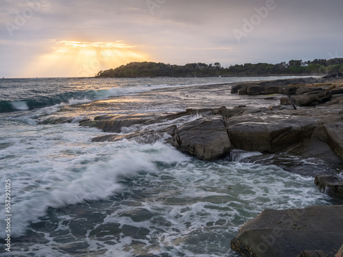 Coastal Sunrise with Waves Crashing on Rocks