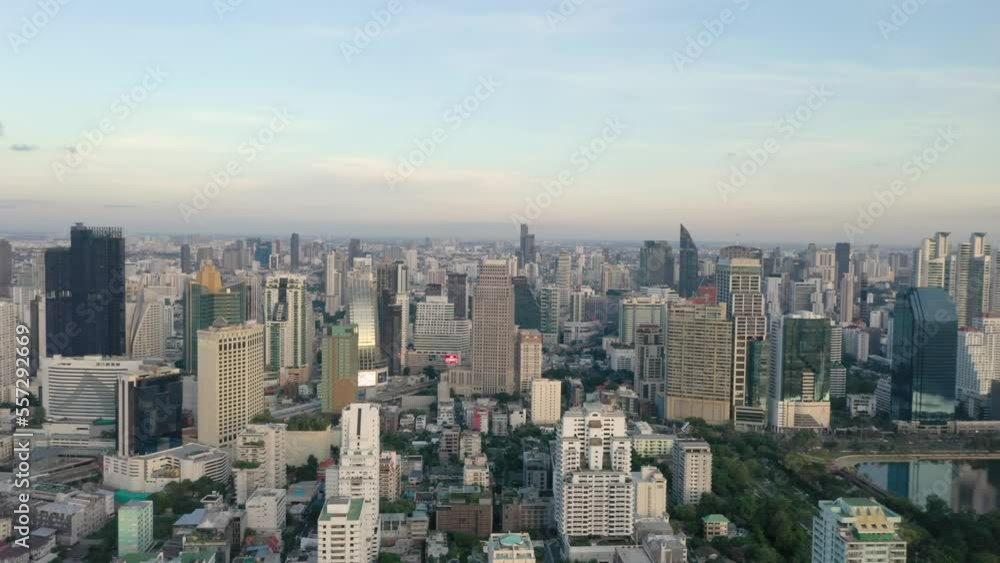 Aerial above skyline and skyscrapers of Sukhumvit district, Pathum Wan and Lumphini Park during sunset in Bangkok, Thailand. Aerial above skyline and skyscrapers of Sukhumvit district, Pathum Wan and Lumphini Park during sunset in Bangkok, Thailand.