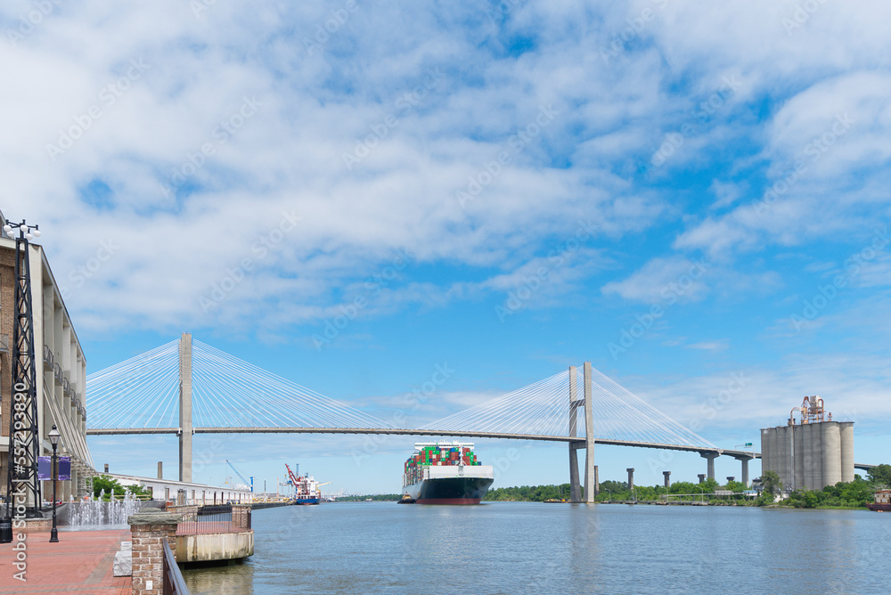 Naklejka premium A barge passes under a suspension bridge on its way out to sea.