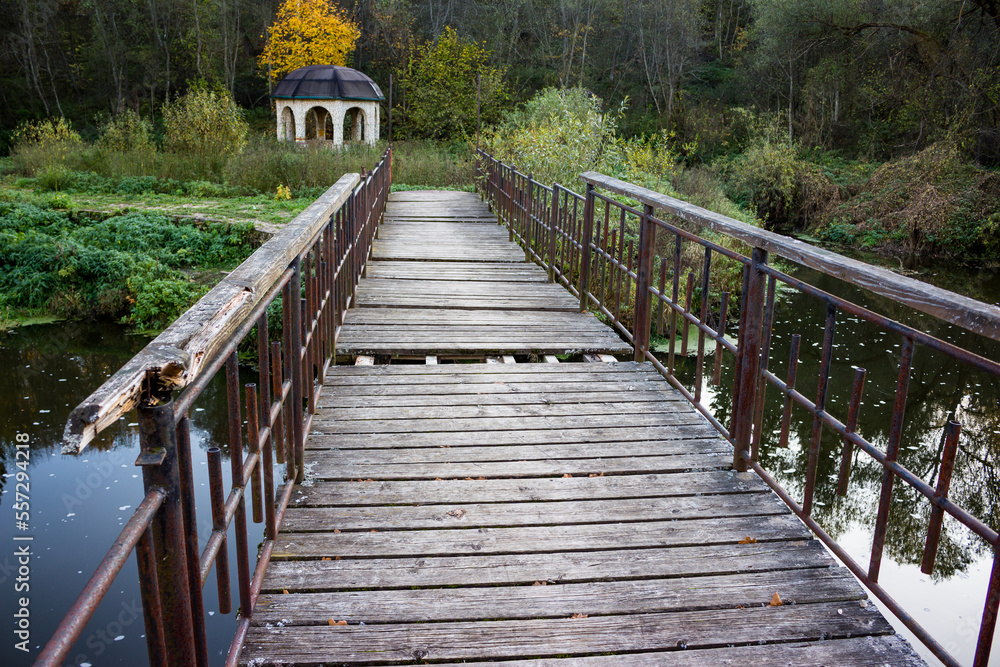 Metal pedestrian bridge with wooden deck across the Nara River, Russia