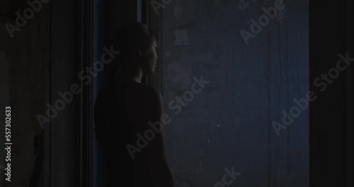 Woman entering dark room of abandoned house. Haunted house concept. Gimbal