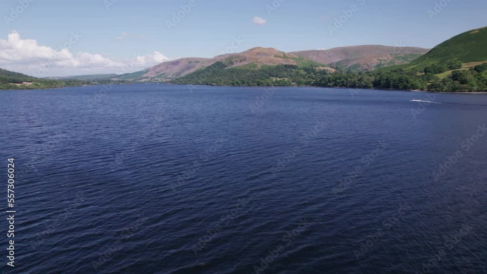 Low drone shot flying forward over Ullswater towards a boat on a sunny day, Lake District, Cumbria, UK Low drone shot flying forward over Ullswater towards a boat on a sunny day, Lake District, Cumbria, UK