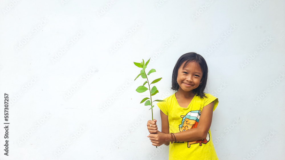 Little girl holding young plant. Green Leaves. Ecology concept. Light color background. Little girl holding young plant. Green Leaves. Ecology concept. Light color background.