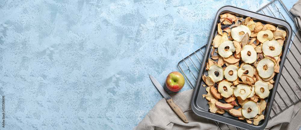 Baking sheet with dried apple chips on blue background with space for text Baking sheet with dried apple chips on blue background with space for text
