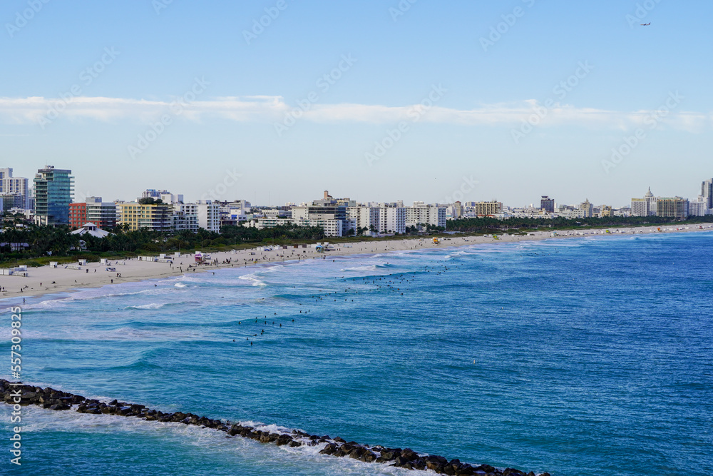Perspective view of Miami Beach and lots of surfers catching waves in the water