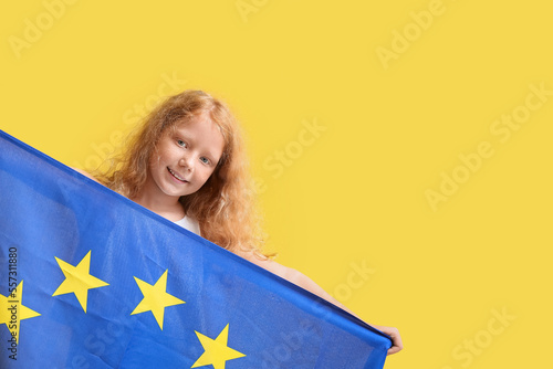 Little girl with flag of European Union on yellow background