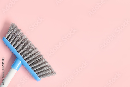Cleaning broom on pink background