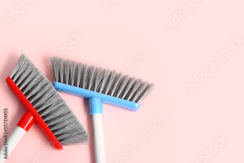 Cleaning brooms on pink background