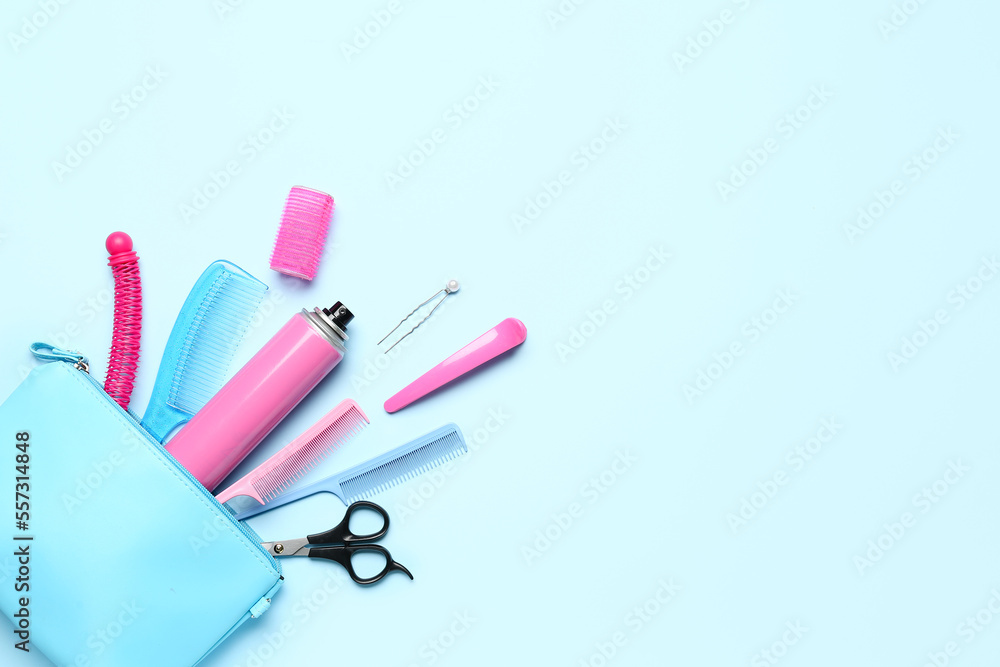 Bag with hair spray, combs, clips and scissors on blue background Bag with hair spray, combs, clips and scissors on blue background