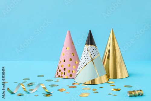 Party hats and confetti on blue background