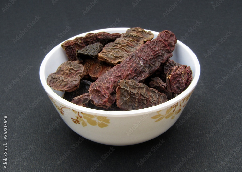 Dried Acacia concinna or Shikakai in a bowl on black background Dried Acacia concinna or Shikakai in a bowl on black background