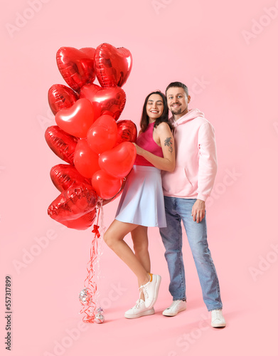 Happy couple in love with balloons on pink background. Valentine's Day celebration © Pixel-Shot