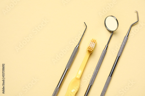 Dental tools with toothbrush on yellow background, closeup