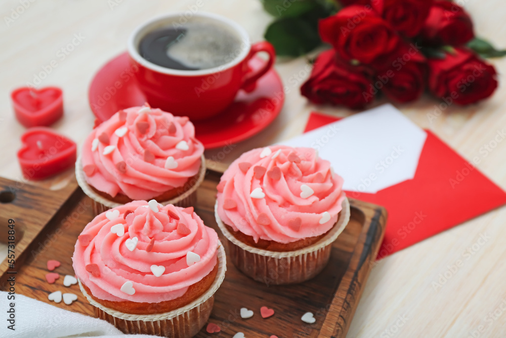 Board with tasty cupcakes for Valentine's Day on wooden background, closeup Board with tasty cupcakes for Valentine's Day on wooden background, closeup