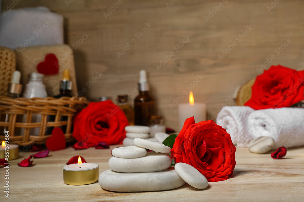 Spa stones with rose and candle on wooden table, closeup. Valentine's Day celebration Spa stones with rose and candle on wooden table, closeup. Valentine's Day celebration
