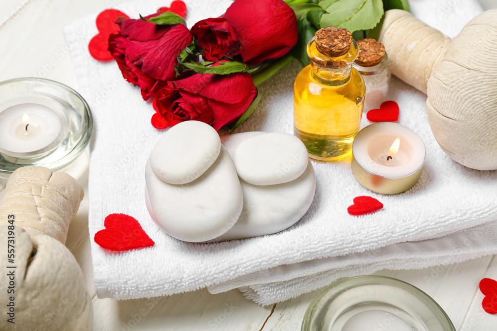 Spa composition for Valentine's Day with stones, roses and candles on white wooden background, closeup Spa composition for Valentine's Day with stones, roses and candles on white wooden background, closeup