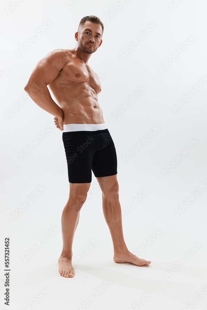 Man athletic body bodybuilder in briefs with naked torso abs full-length in the background, fitness classes. Advertising, sports, active lifestyle, competition, challenge concept. Man athletic body bodybuilder in briefs with naked torso abs full-length in the background, fitness classes. Advertising, sports, active lifestyle, competition, challenge concept.