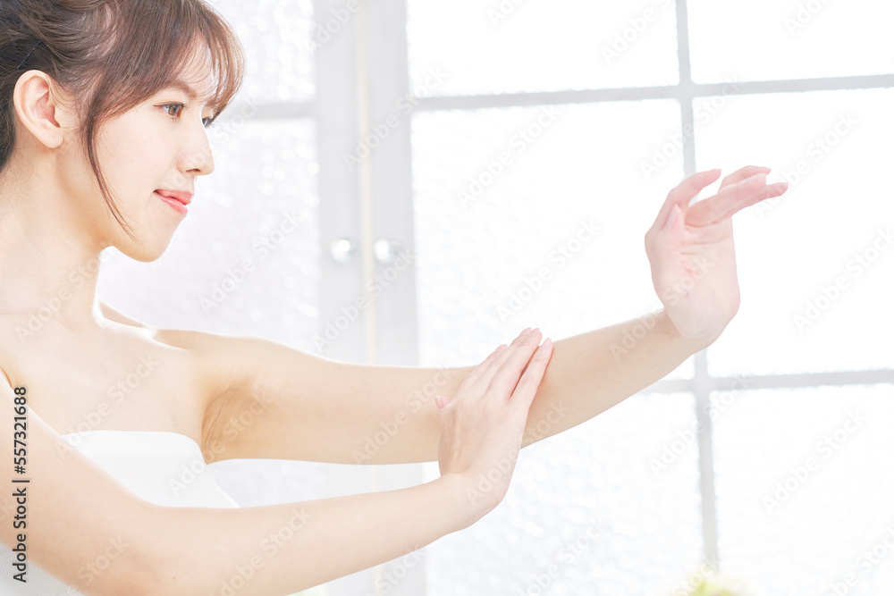 家で腕のケアをする女性