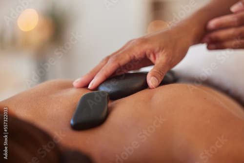 Massage with stone  hands and therapist in spa for wellness and peace  skincare and cosmetic luxury treatment. Holistic care  masseuse and physical therapy with rocks  back muscle relief and relax.