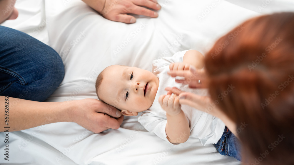 mom and dad sit on the floor and play with the baby. a happy family. family in studio or at home mom and dad sit on the floor and play with the baby. a happy family. family in studio or at home