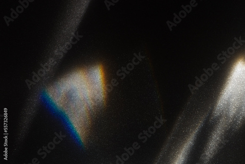 Rainbow light effect from sun flares on black background, colorful glare and shine, light rays on sparkling surface. Rainbow refraction of sunlight. Natural light effects, iridescent colors photo