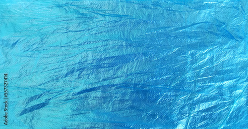 blue plastic surface with rough and crumpled texture.
