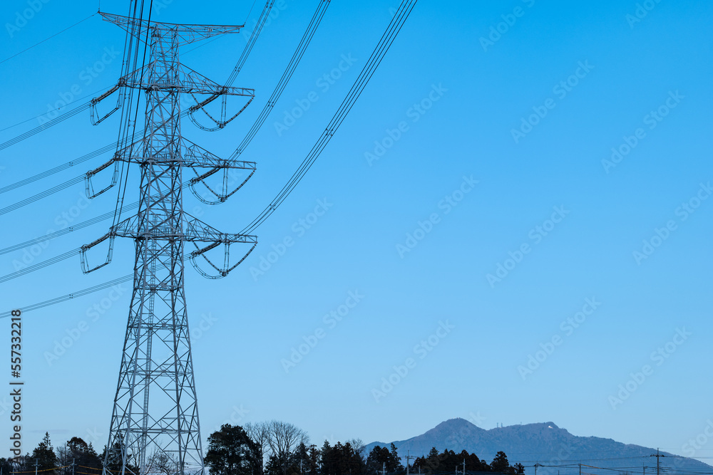 青空の中の高圧送電鉄塔と筑波山