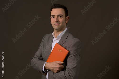 Professional Elegant formal CEO of a company holding a 2023 orange agenda. Concept new year resolution in business. High quality photo
