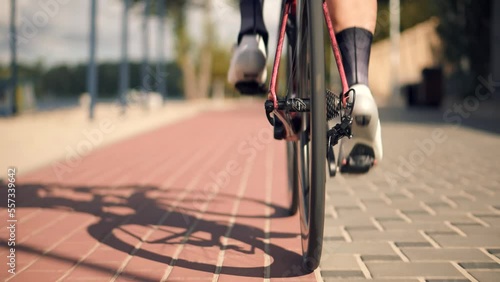 Cyclist training and leisurely twisting pedals on triathlon bicycle	
 photo