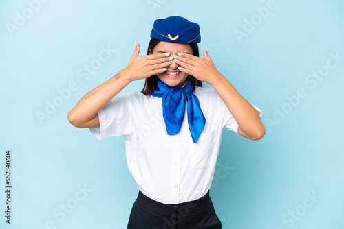 Airplane stewardess caucasian woman isolated on blue background covering eyes by hands