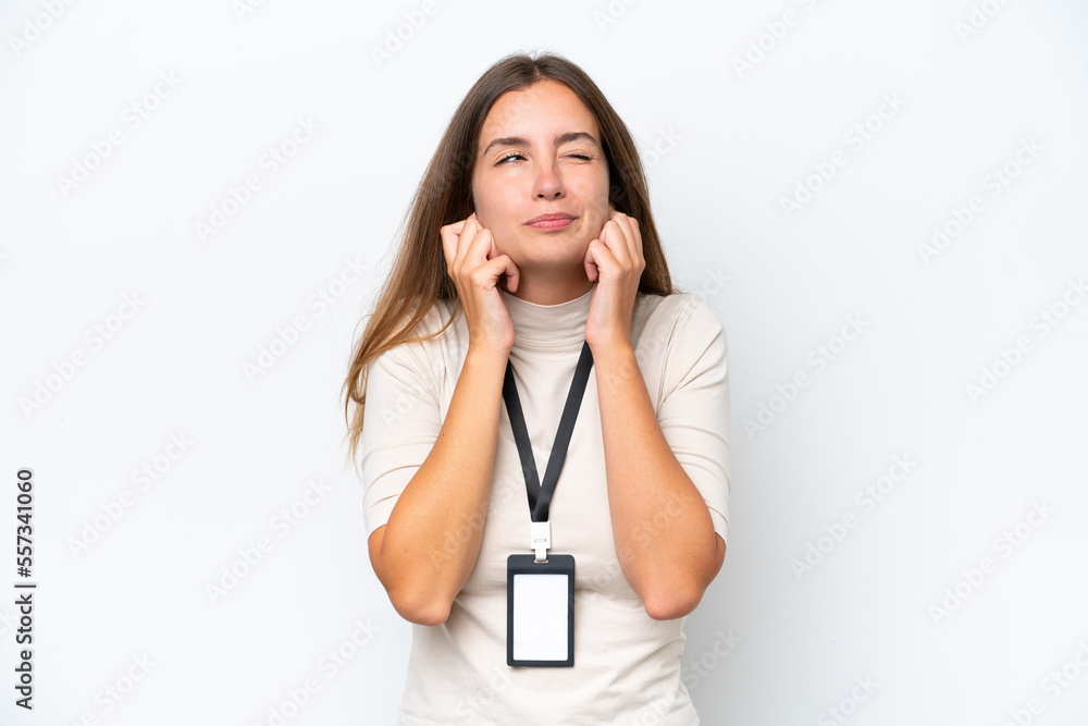 Young pretty woman with ID card isolated on white background frustrated and covering ears Young pretty woman with ID card isolated on white background frustrated and covering ears