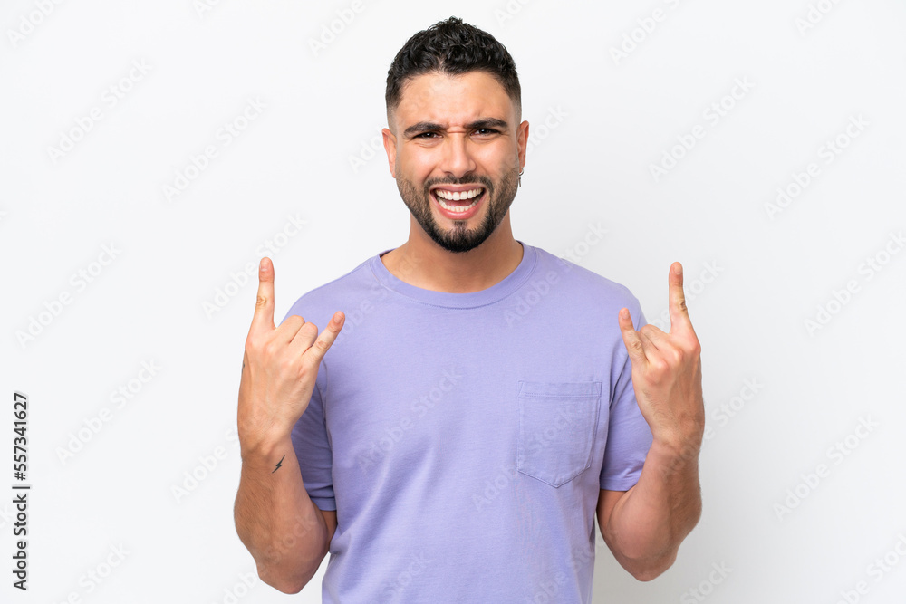 Young Arab handsome man isolated on white background making horn gesture Young Arab handsome man isolated on white background making horn gesture
