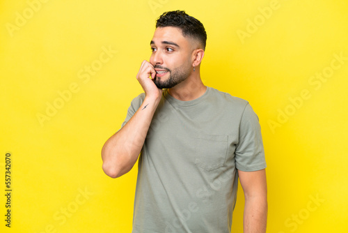 Young Arab handsome man isolated on yellow background is a little bit nervous