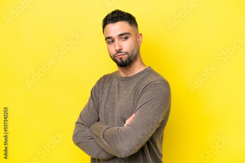 Young Arab handsome man isolated on yellow background keeping the arms crossed