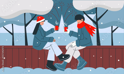 A couple of guy and girl drinking drinks while sitting on a bench under the trees in the winter. Man and woman celebrating outside