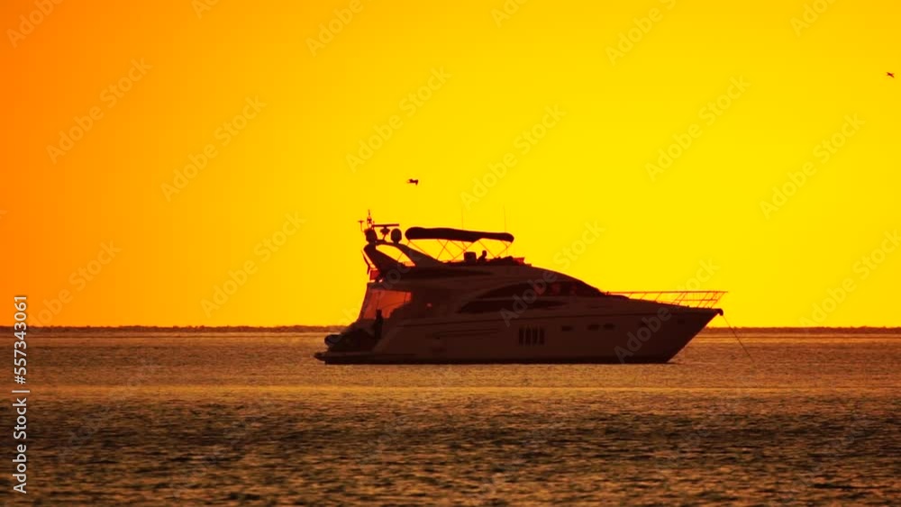 Luxury cruise trip. Red burning sunset over the sea with silhouette of rich yacht. Abstract nature summer ocean sea background. Summer journey on luxury ship Luxury cruise trip. Red burning sunset over the sea with silhouette of rich yacht. Abstract nature summer ocean sea background. Summer journey on luxury ship