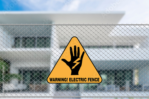 An electric fence warning sign in front of a house. A caution signage to trespassers.